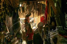 Image du Maroc Professionnelle de  Une femme traverse l'ancienne rue de la Rahba des Attarines (épiciers) au souk Semmarine de Marrakech, on trouve une multitudes d’épices ainsi que d’autres produits que l’on utilise pour la décoration des plats ou des paniers pour les grandes fêtes. Ce qui est insolite c'est que l'on y trouve aussi des objets bizarres qui sont destinés à la sorcellerie et à l’envoûtement, le 8 Décembre 2019. (Photo / Abdeljalil Bounhar) 